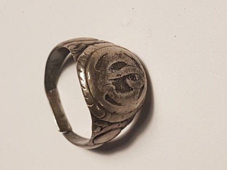 Ein silberfarbener Ring mit Zahl 800 und seltsamen Zeichen