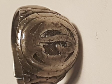 Ein silberfarbener Ring mit Zahl 800 und seltsamen Zeichen